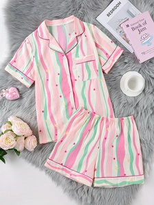 Détail d'un pyjama femme doux avec rayures colorées, étoiles et cœurs sur un tapis en fourrure