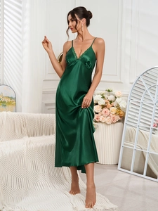 Detail of elegant dark green satin nightgown with delicate lace trim and silk texture