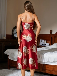 Detail view of red satin nightgown back with elegant white floral print in bedroom