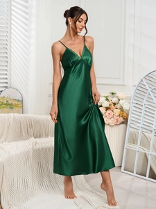 Close-up of elegant dark green satin nightgown featuring delicate lace trim on V-neckline