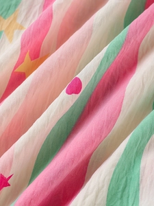 Gros plan du tissu de pyjama en coton léger avec rayures colorées et imprimés d'étoiles
