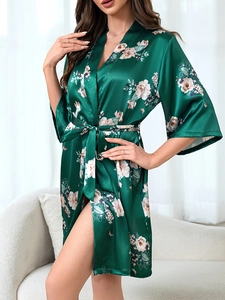 Detail of elegant dark green satin robe featuring vintage floral peony patterns and waist tie
