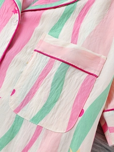 Détail macro du pyjama en coton rayé avec motif étoilé et bordure de poche rose