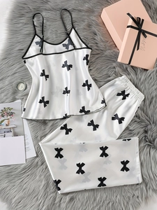 Vue détaillée d'un ensemble caraco en satin blanc à motifs de nœuds noirs sur tapis