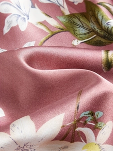 Gros plan sur un tissu en satin rose avec imprimé lys élégant et éclat soyeux