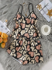 Detailansicht beige Satin-Schlafanzug mit Herz-Leopard-Muster auf Plüschhintergrund