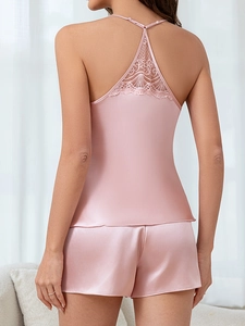 Detailed back view of pink satin pajama set featuring delicate lace trim on camisole