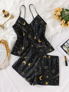 Detail des schwarzen Satin-Pyjamas mit goldenen Mond- und Sternenmustern im Set