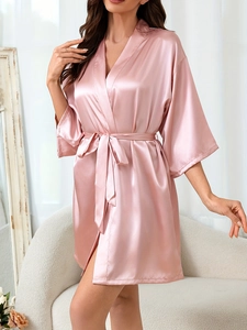 Détail de la texture lisse et de la ceinture ajustable du peignoir en satin rose