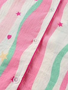 Détail du tissu de pyjama rayé avec motifs d'étoiles et fermeture à bouton blanc