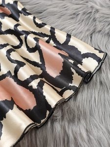 Detailansicht von Satin mit Leopardenmuster, seidiger Textur und feiner Saumnaht