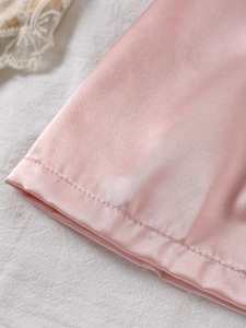 Vue macro détaillée du tissu en satin rose clair avec des coutures fines de qualité