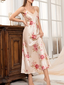 Detail of champagne satin slip dress featuring elegant floral prints and silky texture