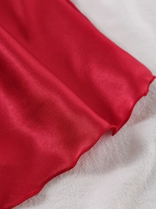 Détail macro d'une chemise de nuit en satin rouge avec bordure ondulée élégante