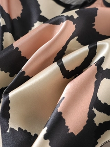 Detailaufnahme von glattem Satinstoff mit elegantem Leopardenmuster und Seidenglanz