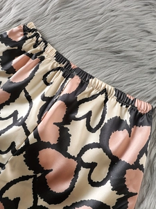 Detailansicht des Gummibunds der Satin-Pyjama-Shorts mit rosa Herz-Tierprint-Muster