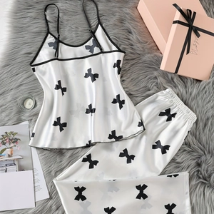 Ensemble de pyjama deux pièces en satin blanc avec motifs de nœuds noirs et bretelles