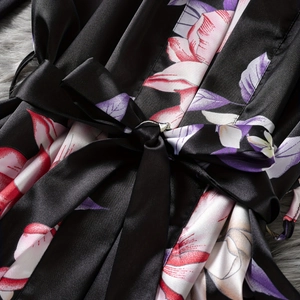 Women's black satin kimono robe featuring vibrant floral patterns and a matching waist tie