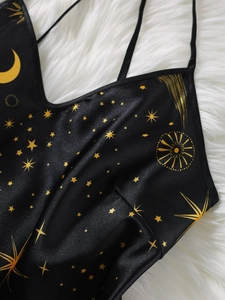 Detailansicht des schwarzen Satin-Tops mit goldenen Mond- und Sternen-Prints