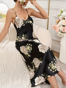 Detail of elegant black floral satin nightgown with adjustable spaghetti straps and V-neckline