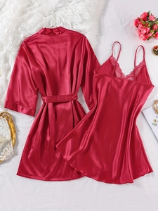 Flat lay of red satin sleepwear set with lace trim and elegant floral props