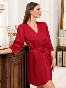 Détail du peignoir en satin rouge montrant la texture soyeuse et les coutures bouffantes