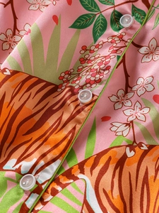 Detailed close-up of pink silk pajamas with jungle tiger print and green piping details