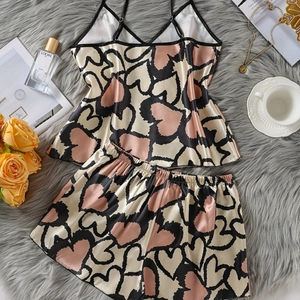 Damen Satin Pyjama Set mit Herzmuster Camisole und Shorts auf Plüsch Hintergrund