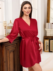 Détail du peignoir en satin rouge foncé avec texture soyeuse et ceinture à nouer