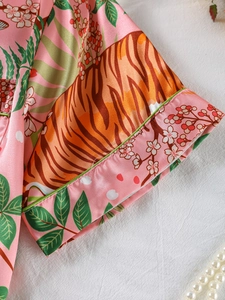 Detail of pink satin sleepwear showing exotic tiger print and green contrast piping