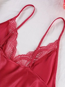 Detail of red satin camisole with intricate lace trim neckline and adjustable straps