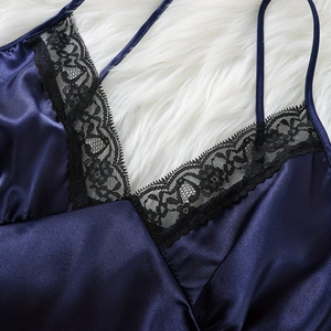 Navy blue satin camisole with black lace trim on V-neck against white faux fur background