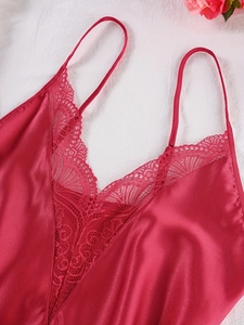 Detail of red satin sleepwear with intricate floral lace trim and V-neckline