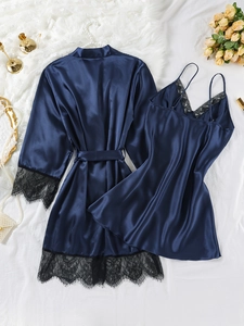 Detail of dark blue satin sleepwear set with black lace trim and silk texture