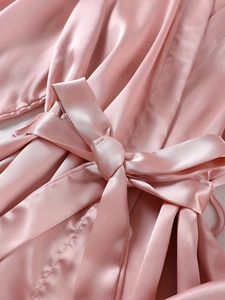 Vue détaillée du peignoir en satin rose avec nœud à la taille et texture soyeuse élégante