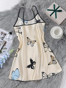 Flat lay of champagne satin nightdress with colorful butterfly print and lace detail