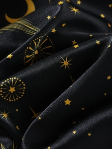 Détail de tissu en satin noir avec motifs dorés d'étoiles et de lune pour pyjama