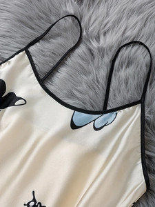 Detail of cream silk satin camisole with black trim and abstract butterfly prints