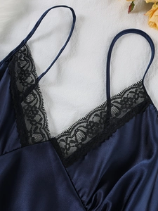 Close-up of deep blue satin nightgown with black lace V-neck and delicate straps
