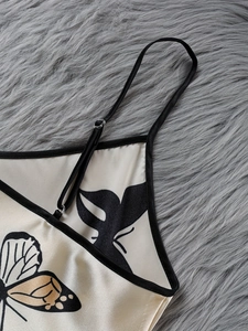 Detail of adjustable strap and butterfly print on smooth satin sleepwear dress