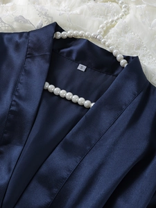Close-up of S size label on deep blue satin sleepwear with delicate lace and pearls