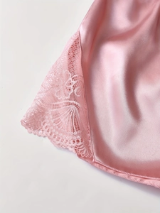 Vue détaillée du tissu en soie rose avec bordure en dentelle élégante et broderie