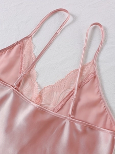 Détail d'un vêtement de nuit en satin rose avec dentelle fine et fines bretelles