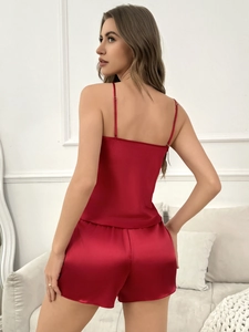Detail of red satin two-piece sleepwear set featuring camisole top and matching shorts