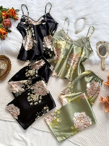 Ensembles de pyjama en satin à fleurs noir et vert présentés sur fond moelleux