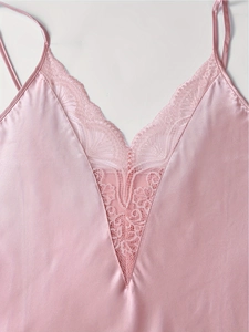 Détail du caraco en satin rose avec décolleté en V et dentelle florale délicate