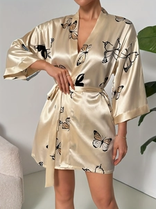 Detail of silk-satin champagne robe featuring butterfly print and sleek waist tie