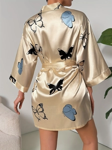 Close-up of champagne satin robe featuring butterfly print and luxurious fabric texture