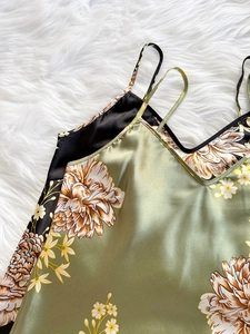 Détail du caraco en satin à imprimé floral avec fines bretelles sur fond de fausse fourrure
