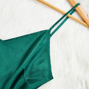 Elegante set pigiama tre pezzi in raso verde smeraldo su gruccia in legno e base in pelliccia